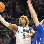 
              Villanova guard Justin Moore (5) takes the ball to the basket past Creighton center Ryan Kalkbrenner (11) during the second half of an NCAA college basketball game, Wednesday, Jan. 5, 2022, in Villanova, Pa. (AP Photo/Laurence Kesterson)
            