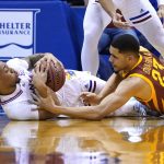 
              Kansas guard Bobby Pettiford (0) and Iowa State guard Tristan Enaruna (23) battle for a loose ball in the first half of an NCAA college basketball game Tuesday, Jan. 11, 2022, in Lawrence, Kan. (AP Photo/Ed Zurga)
            