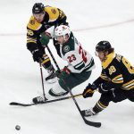 
              Minnesota Wild's Marco Rossi (23) works between Boston Bruins' Erik Haula (56) and David Pastrnak (88) for the puck during the first period of an NHL hockey game Thursday, Jan. 6, 2022, in Boston. (AP Photo/Michael Dwyer)
            
