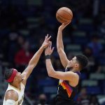 
              Phoenix Suns guard Devin Booker (1) shoots against New Orleans Pelicans guard Josh Hart in the first half of an NBA basketball game in New Orleans, Tuesday, Jan. 4, 2022. (AP Photo/Gerald Herbert)
            