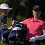 
              CORRECTS DAY AND DATE TO SATURDAY, JAN. 29, 2022, AND NOT TUESDAY, MARCH 1, 2022, AS ORIGINALLY SENT - Yuka Saso of the Philippines takes her jacket back from her caddy after teeing off on the fifth hole, during the third round of the Gainbridge LPGA golf tournament, Saturday, Jan. 29, 2022, in Boca Raton, Fla. (AP Photo/Rebecca Blackwell)
            