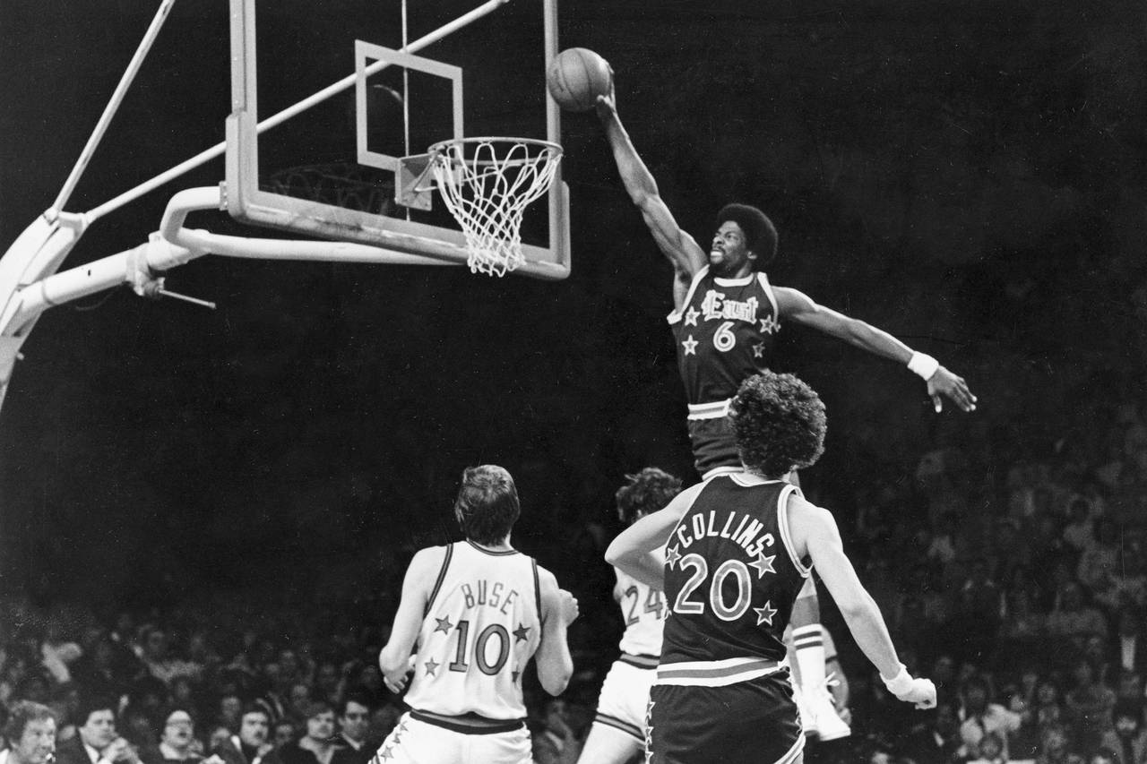 FILE - Sixers' Julius Erving (6) dunks the ball through the basket over Chicago Bulls' Artis Gilmor...