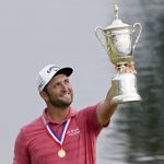 
              FILE - Jon Rahm, of Spain, holds the champions trophy for photographers after the final round of the U.S. Open Golf Championship, on June 20, 2021, at Torrey Pines Golf Course in San Diego. The world No. 1 returns to the site of his U.S. Open victory this week for the Farmers Insurance Open, a tournament he has also won before. (AP Photo/Jae C. Hong, File)
            