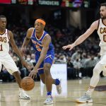 
              New York Knicks' Immanuel Quickley (5) drives between Cleveland Cavaliers' Rajon Rondo (1) and Kevin Love (0) in the second half of an NBA basketball game, Monday, Jan. 24, 2022, in Cleveland. (AP Photo/Tony Dejak)
            
