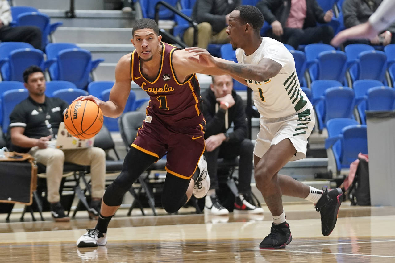 Loyola guard Lucas Williamson (1) drives as San Francisco guard Jamaree Bouyea (1) defends in the f...