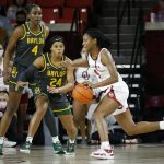 
              Oklahoma guard Kennady Tucker (4) drives the ball against Baylor guard Sarah Andrews (24) and center Queen Egbo (4) during the first half of an NCAA college basketball game Wednesday, Jan. 12, 2022, in Norman, Okla. (AP Photo/Garett Fisbeck)
            