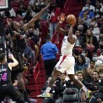 
              Los Angeles Clippers forward Justise Winslow, right, looks to pass as Miami Heat center Bam Adebayo (13) defends during the first half of an NBA basketball game, Friday, Jan. 28, 2022, in Miami. (AP Photo/Lynne Sladky)
            
