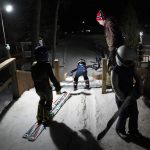 
              Julia Lindquist, 4, center, heads down the 5-meter ski jump as Erik Bakk-Hansen monitors the start of the kids practicing Tuesday, Jan. 18, 2022, at the Norge Ski Club in Fox River Grove, Ill. With the fearlessness befitting a 4-year-old, she shuffled her skis to the top of the 5-meter hill (16.4 feet) in between two wood posts and nudged herself down the run. (AP Photo/Charles Rex Arbogast)
            