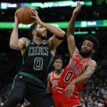
              Boston Celtics' Jayson Tatum, left, shoots against Chicago Bulls' Coby White during the second half of an NBA basketball game, Saturday, Jan. 15, 2022, in Boston. (AP Photo/Michael Dwyer)
            