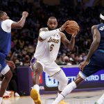 
              Los Angeles Lakers forward LeBron James (6) drives between Minnesota Timberwolves center Naz Reid (11) and Jarred Vanderbilt (8) during the first half of an NBA basketball game in Los Angeles, Sunday, Jan. 2, 2022. (AP Photo/Ringo H.W. Chiu)
            