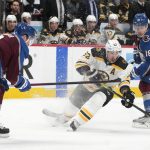 
              Boston Bruins left wing Brad Marchand, center, fights to control the puck while driuving between Colorado Avalanche defenseman Cale Makar, left, and center Alex Newhook in the second period of an NHL hockey game Wednesday, Jan. 26, 2022, in Denver. (AP Photo/David Zalubowski)
            