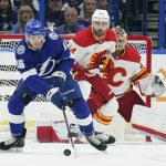 
              Tampa Bay Lightning right wing Taylor Raddysh (16) tries to control the puck in front of Calgary Flames defenseman Erik Gudbranson (44) and goaltender Dan Vladar (80) during the first period of an NHL hockey game Thursday, Jan. 6, 2022, in Tampa, Fla. (AP Photo/Chris O'Meara)
            