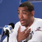 
              FILE - Connecticut coach Kevin Ollie speaks during a news conference ahead of a second-round men's college basketball game in the NCAA Tournament in Des Moines, Iowa, March 18, 2016. An independent arbiter has ruled that UConn improperly fired former men's basketball coach Kevin Ollie and must pay him more than $11 million, Ollie's lawyer said Thursday, Jan. 20, 2022. (AP Photo/Nati Harnik, File)
            