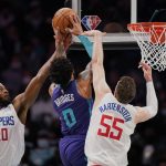 
              Los Angeles Clippers forward Justise Winslow (20) and center Isaiah Hartenstein (55) attempt to defend the basket from Charlotte Hornets forward Miles Bridges (0) during the first half of an NBA basketball game Sunday, Jan. 30, 2022, in Charlotte, N.C. (AP Photo/Rusty Jones)
            