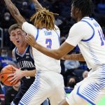 
              Villanova guard Collin Gillespie, left, looks to pass against DePaul guard Jalen Terry, center, and DePaul center Nick Ongenda during the first half of an NCAA college basketball game in Chicago, Saturday, Jan. 8, 2022. Villanova won 79-64. (AP Photo/Nam Y. Huh)
            