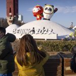 
              People wearing face masks to help protect against the coronavirus look at a display of the Winter Paralympic mascot Shuey Rhon Rhon, left, and Winter Olympic mascot Bing Dwen Dwen near the Olympic Green in Beijing, Wednesday, Jan. 12, 2022. Just weeks before hosting the Beijing Winter Olympics, China is battling multiple coronavirus outbreaks in half a dozen cities, with the one closest to the capital driven by the highly transmissible omicron variant. (AP Photo/Mark Schiefelbein)
            