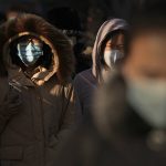 
              Women wearing face masks to protect from the coronavirus head to work during the morning rush hour in Beijing, Monday, Jan. 10, 2022. Tianjin, a major Chinese city near Beijing has placed its 14 million residents on partial lockdown after a number of children and adults tested positive for COVID-19, including at least two with the omicron variant. (AP Photo/Andy Wong)
            