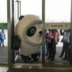 
              FILE - Inflated Beijing Games mascot, Bing Dwen Dwen, tries to squeeze through the door to enter the main media center at the 2022 Winter Olympics, Monday, Jan. 24, 2022, in Beijing. Athletes and others headed to the Olympics face a multitude of COVID-19 testing hurdles as organizers seek to catch any infections early and keep the virus at bay. (AP Photo/Jae C. Hong, File)
            