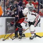 
              Columbus Blue Jackets' Vladislav Gavrikov, left, and Chicago Blackhawks' Dylan Strome fight for a loose puck during the third period of an NHL hockey game Tuesday, Jan. 11, 2022, in Columbus, Ohio. (AP Photo/Jay LaPrete)
            