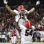 
              Georgia tight end Brock Bowers gets a hoist from Justin Shaffer after scoring on a 15 yard pass to take a 26-18 lead over Alabama during the 4th quarter in the College Football Playoff Championship game on Monday, Jan. 10, 2022, in Indianapolis. (Curtis Compton/Atlanta Journal-Constitution via AP)
            