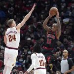 
              Chicago Bulls' DeMar DeRozan (11) passes under pressure from Cleveland Cavaliers' Lauri Markkanen (24) as Darius Garland (10) also defends during the first half of an NBA basketball game Wednesday, Jan. 19, 2022, in Chicago. (AP Photo/Charles Rex Arbogast)
            