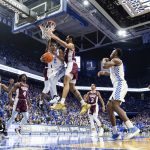 
              Kentucky guard Sahvir Wheeler (2) passes the ball off while being guarded by Mississippi State guard Iverson Molinar, behind Wheeler, and forward Garrison Brooks, right, during the first half of an NCAA college basketball game in Lexington, Ky., Tuesday, Jan. 25, 2022. (AP Photo/Michael Clubb)
            