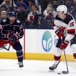 
              New Jersey Devils forward Jimmy Vesey, right, controls the puck in front of Columbus Blue Jackets forward Boone Jenner during the second period of an NHL hockey game in Columbus, Ohio, Saturday, Jan. 8, 2022. (AP Photo/Paul Vernon)
            