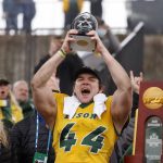 
              North Dakota State fullback Hunter Luepke (44) celebrates with his most valuable player award after the FCS Championship NCAA college football game against Montana State, Saturday, Jan. 8, 2022, in Frisco, Texas.  (AP Photo/Michael Ainsworth)
            