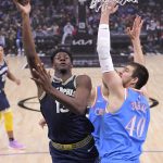 
              Memphis Grizzlies forward Jaren Jackson Jr., left, shoots as Los Angeles Clippers center Ivica Zubac defends during the first half of an NBA basketball game Saturday, Jan. 8, 2022, in Los Angeles. (AP Photo/Mark J. Terrill)
            