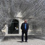 
              FILE - Dissident Chinese artist Ai Weiwei poses by his sculpture "Forever Bicycles" during a press preview of his new exhibition "Rapture" in Lisbon on June 3, 2021. Ai is one of China's most famous artists, and many regard him as one of the world's greatest living artists. Working with the Swiss architectural firm Herzog & de Meuron, he helped design the Bird's Nest stadium, the centerpiece of Beijing's 2008 Summer Olympics. The stadium will also host the opening ceremony for Beijing's Winter Olympics on Feb. 4, 2022. (AP Photo/Armando Franca, File)
            
