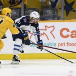 
              Nashville Predators left wing Tanner Jeannot (84) and Winnipeg Jets left wing Kyle Connor (81) reach for the puck during the first period of an NHL hockey game Thursday, Jan. 20, 2022, in Nashville, Tenn. (AP Photo/Mark Zaleski)
            