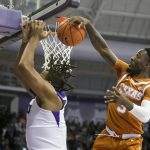 
              Texas guard Courtney Ramey, right, blocks TCU center Eddie Lampkin, left, in the first half of an NCAA college basketball game in Fort Worth, Texas, Tuesday, Jan. 25, 2022. (AP Photo/Gareth Patterson)
            