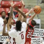 
              Utah guard Rollie Worster, right, shoots while pressured by Washington State forwards DJ Rodman, left, and Efe Abogidi during the second half of an NCAA college basketball game, Wednesday, Jan. 26, 2022, in Pullman, Wash. Washington State won 71-54. (AP Photo/Young Kwak)
            