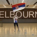
              A fan of Serbia's Novak Djokovic waves a flag in the arrivals hall at Melbourne Airport ahead of the Australian Open in Melbourne, Australia, Thursday, Jan. 6, 2022. The Australian government has denied No. 1-ranked Djokovic entry to defend his title in the year's first tennis major and canceled his visa because he failed to meet the requirements for an exemption to the country's COVID-19 vaccination rules. (AP Photo/Hamish Blair)
            