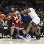 
              Oklahoma forward Tanner Groves (35) passes while defended by West Virginia forward Pauly Paulicap (1) during the first half of an NCAA college basketball game in Morgantown, W.Va., Wednesday, Jan. 26, 2022. (AP Photo/Kathleen Batten)
            