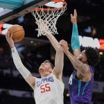 
              Los Angeles Clippers center Isaiah Hartenstein (55) attempts to shoot past Charlotte Hornets forward Miles Bridges, right, during the first half of an NBA basketball game Sunday, Jan. 30, 2022, in Charlotte, N.C. (AP Photo/Rusty Jones)
            