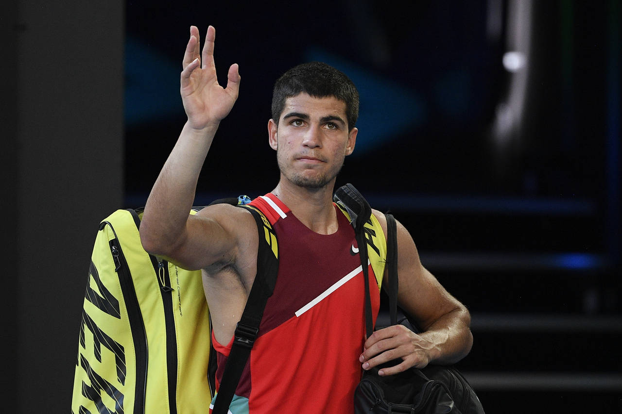 Carlos Alcaraz of Spain waves as he leaves Rod Laver Arena following his third round loss to Matteo...
