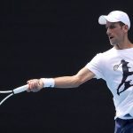 
              Defending champion Serbia's Novak Djokovic, plays a forehand return during a practice session in the Rod Laver Arena ahead of the Australian Open at Melbourne Park in Melbourne, Australia, Tuesday, Jan. 11, 2022. The prime ministers of Australia and Serbia have discussed Novak Djokovic's precarious visa after the top-ranked Serbian tennis star won a court battle to compete in the Australian Open but still faces the threat of deportation because he is not vaccinated against COVID-19. (Kelly Defina/Pool Photo via AP)
            