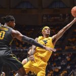 
              West Virginia forward Jalen Bridges (11) attempts a shot while being guarded by Baylor forward Flo Thamba (0) during the first half of an NCAA college basketball game in Morgantown, W.Va., Tuesday, Jan. 18, 2022. (William Wotring)
            