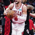 
              Chicago Bulls guard Zach LaVine, center, drives to the basket against Portland Trail Blazers forwards Norman Powell, left, and Robert Covington during the second half of an NBA basketball game in Chicago, Sunday, Jan. 30, 2022. (AP Photo/Nam Y. Huh)
            