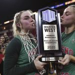 
              Fresno State's Haley Cavinder, left, and her sister Hanna Cavinder, right, pose with the Mountain West Conference regular season champions trophy after defeating San Jose State in an NCAA college basketball game on Feb. 12, 2020, in Fresno, Calif. It is a man's world six months after the NCAA cleared the way for college athletes to earn money on their celebrity. Men lead the way in total name, image and likeness compensation and have more NIL activities than women. (Eric Paul Zamora/The Fresno Bee via AP)
            