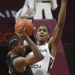 
              Miami's Kameron McGusty (23) looks to pass as Virginia Tech's David N'Guessan (1) defends during the first half of an NCAA college basketball game, Wednesday, Jan. 26 2022, in Blacksburg Va. (Matt Gentry/The Roanoke Times via AP)
            