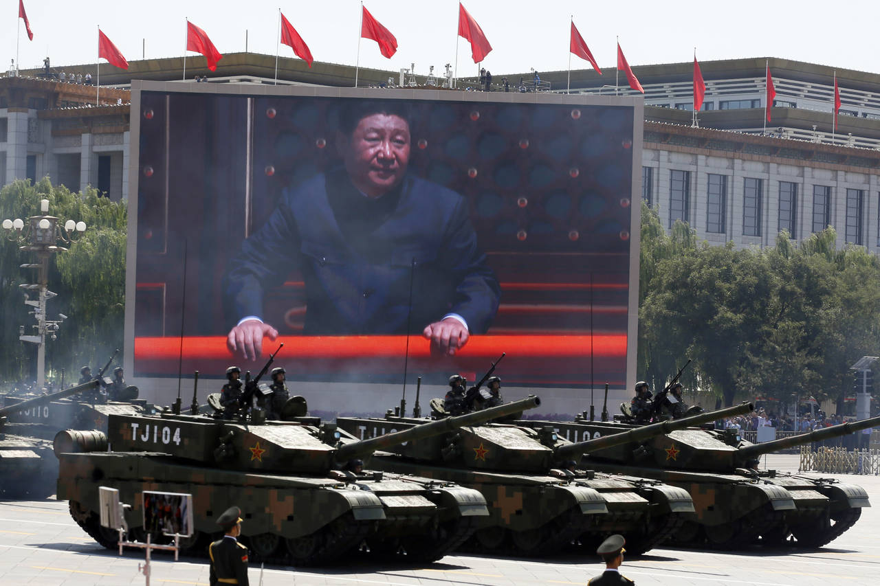 FILE - Chinese President Xi Jinping is displayed on a screen as Type 99A2 Chinese battle tanks take...