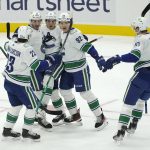 
              Vancouver Canucks right wing Vasily Podkolzin, second from right, is greeted by teammates after he scored a goal against the Seattle Kraken during the first period of an NHL hockey game Saturday, Jan. 1, 2022, in Seattle. (AP Photo/Ted S. Warren)
            