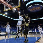 
              UCLA guard Jaylen Clark (0) shoots against Oregon center Franck Kepnang (22) and guard Jacob Young (42) during the first half of an NCAA college basketball game in Los Angeles, Thursday, Jan. 13, 2022. The arena was empty, except for family members of players due to the spread of COVID-19. (AP Photo/Ashley Landis)
            