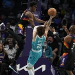
              Charlotte Hornets guard LaMelo Ball shoots between Phoenix Suns guard Chris Paul, right, and forward Jalen Smith during the first half of an NBA basketball game on Sunday, Jan. 2, 2022, in Charlotte, N.C. (AP Photo/Chris Carlson)
            