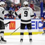 
              Los Angeles Kings center Adrian Kempe (9) is congratulated by Anze Kopitar after scoring an empty net goal in the third period of an NHL hockey game against the New York Islanders on Thursday, Jan. 27, 2022, in Elmont, N.Y. The Kings won 3-2. (AP Photo/Adam Hunger)
            