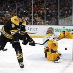 
              Boston Bruins' Mike Reilly backhands a shot past Nashville Predators goaltender Juuse Saros for a goal during the first period of an NHL hockey game Saturday, Jan. 15, 2022, in Boston. (AP Photo/Winslow Townson)
            