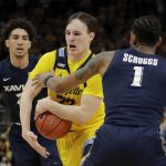 
              Marquette's Tyler Kolek drives to the basket against Xavier's Paul Scruggs (1) and Colby Jones during the first half of an NCAA college basketball game Sunday, Jan. 23, 2022, in Milwaukee. (AP Photo/Aaron Gash)
            