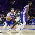 
              Philadelphia 76ers' Seth Curry, left, uses Joel Embiid, right, as a screen to get away from Boston Celtics' Dennis Schroder, center, during the first half of an NBA basketball game, Friday, Jan. 14, 2022, in Philadelphia. (AP Photo/Chris Szagola)
            